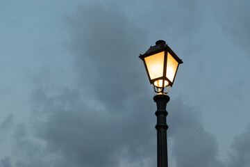 Fototapeta na wymiar Silhouette of a street lamp in the cloudy evening