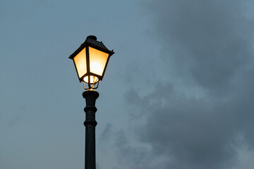 Fototapeta na wymiar Silhouette of a street lamp in the cloudy evening