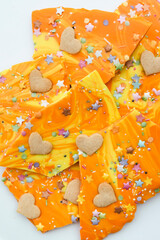 Orangefarbene Bruchschokolade mit Herzen und Sternen