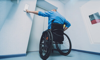 Person with a physical disability who uses wheelchair using lift in building