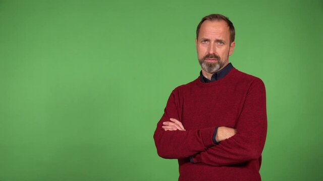 A middle-aged handsome Caucasian man shakes his head at the camera - green screen background