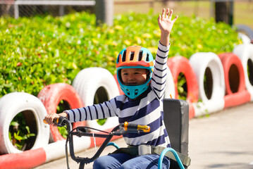 Naklejka premium Asian boy drive go-cart at the amusement park