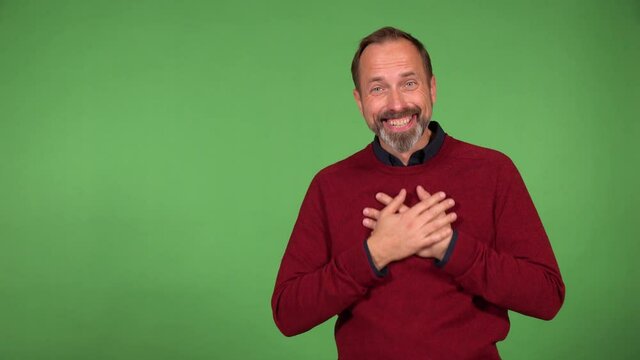 A middle-aged handsome Caucasian man is excited and laughs at the camera - green screen background