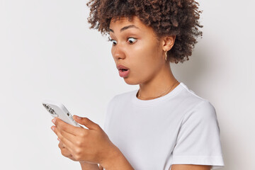 Impressed shocked woman stares with amazement at smartphone screen reacts to cool new device or app...