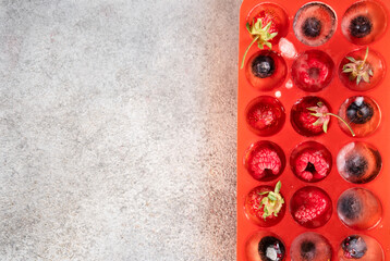 Frozen berries in ice cubes covered with hoarfrost. Homemade food. Top view.