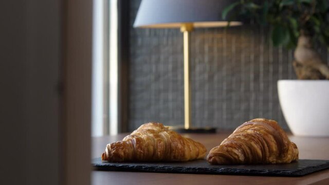 Two fresh delicious croissants on a tray on the table