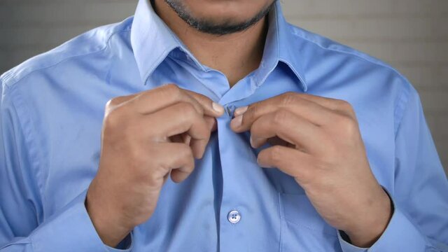 Man buttoning his shirt close up