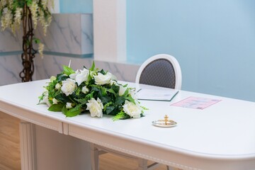 A bouquet of beautiful flowers lies on the table in the registry office 