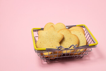Homemade shortbread cookies on a pink background. Delicious and light dessert. Cookies in a shopping basket