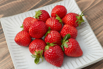 平たい皿に盛り付けられた旬の甘いイチゴ