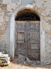 Old wooden door of traditional stone house in Campi, a dreamy mountain village in Castagniccia.Corsica, France.