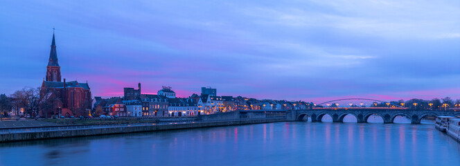 panoramic image of the skyline of Maastricht during the blue hour with views on the Sint Servaas bridge, the boat company for day trips and trendy neighborhood Wyck