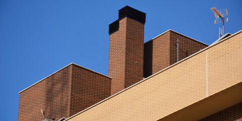 Ático y chimenea de ladrillo en un día soleado. 