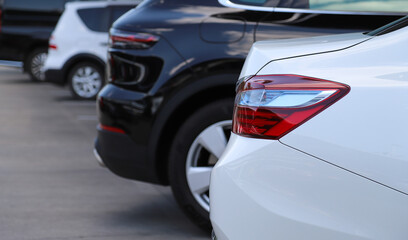 Closeup of rear, back side of white car parking in outdoor parking area.