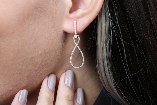 Jewelry, earrings in a beautiful girl's ear, women's accessories, gold earrings, earrings with stones, special diamonds