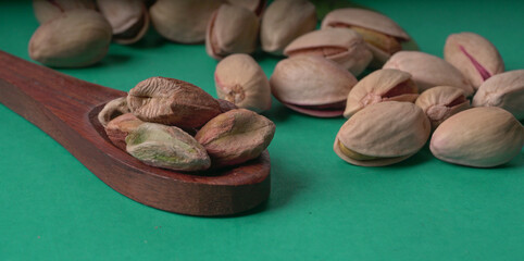 Pistachios or Pista nuts decorated with green leaves. plain background, top view.Flat lay.
