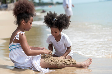 happy african american Little girl play and  buried in sand on the beach