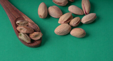 Pistachios or Pista nuts decorated with green leaves. plain background, top view.Flat lay.

