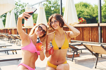 Having a conversation. Women in swimsuits have fun outdoors together at summertime