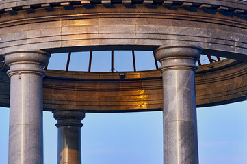 Dome of a marble rotunda made of transparent glass. Sunlight at dawn. Details of architecture on the embankment of the city of Blagoveshchensk, Russia.