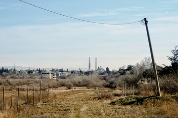 Deserted area with factory pipes on horizon.