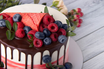Cake with berries on a light wood background