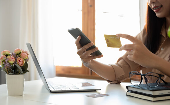 Happy woman using mobile app to online shopping and pay whit credit card at home
