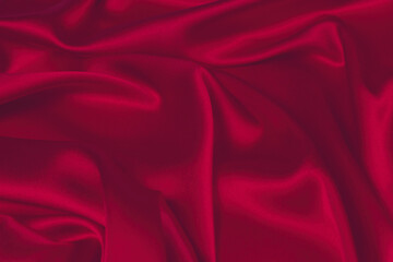 Red silk or satin luxury fabric texture can use as abstract background. Top view.