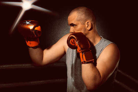 A left - handed boxer attacks in the ring . A fighter in red boxing gloves fights for the belt . A man in a rack in the corner of the ring .