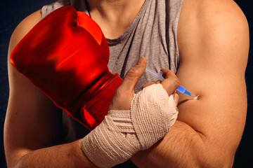 A boxer injects doping into his arm before a fight. The fighter administers a steroid injection. An...