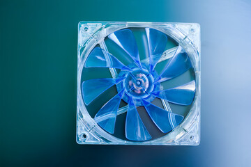 Blue computer fan with blades on a green-blue background. Computer case cooling fans, CPU cooling...