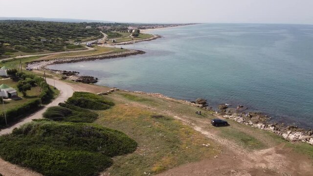 Inquadratura zoom-out aereo con drone su Torre Mileto, Gargano in Puglia. Inquadratura con carrellata all'indietro con scoprimento della torre verso il mare. Torri costiere di avvistamento nel Gargano