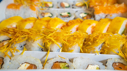 Large sushi set on black. An assortment of various maki, nigiri and rolls. Close up.