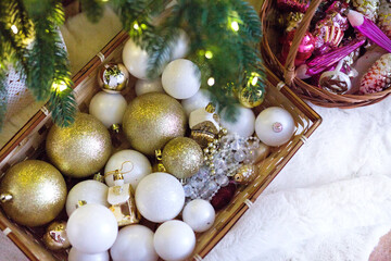 Fototapeta na wymiar Christmas tree toys in a basket under the tree. Christmas decoration