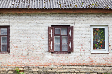 Fototapeta na wymiar Window with wooden shutters and window with plastic frame