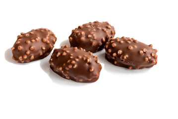Chocolate candies with cream filling and crushed hazelnuts on an isolated white background. 