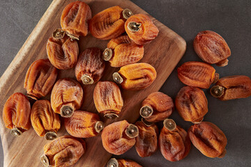 Dried persimmons on a wooden chopping board
