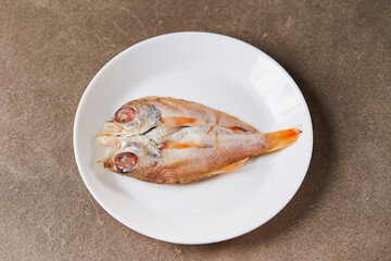 dried red fish on a plate