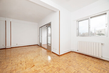 Large empty room with access to a terrace with windows and light oak parquet floors
