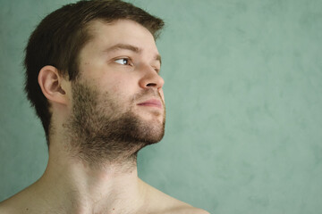 Obraz premium lifestyle candid morning portrait of an unshaved young man. attractive face with bristle. men beauty