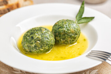 Close-up of canederli with spinach served in soup - bread dumplings made from dried bread rolls,...