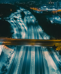 City street in winter night aerial view. The road is illuminated by lanterns. Drone view