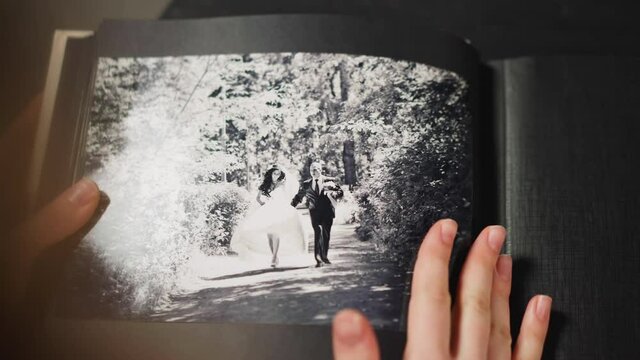 Lady strokes faded image of grandparents wedding in album