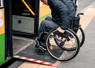 Person with a physical disability enters public transport with an accessible ramp.