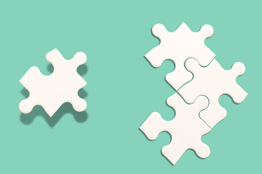 White Jigsaw Puzzle On Green Background, Find The Right Joined Team And Fit Correctly Concept