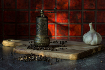 Turkish Grinder, Spice Grinder, Salt Grinder, Pepper Mill on a wooden board with loose black pepper corns
