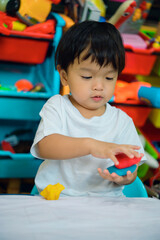 baby boy child playing with sensor kinetic toy playdough. Hand brain development activity