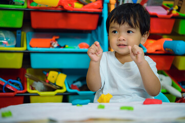 baby boy child playing with sensor kinetic toy playdough. Hand brain development activity