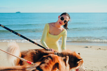 Woman with her siberian husky dog playing on the sea shore,beach