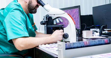 Laboratory assistant works with microscope at the modern laboratory.